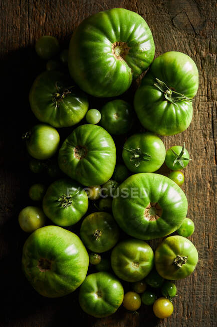 De cima tomates verdes não maduros colocados na mesa de madeira na estação de colheita — Fotografia de Stock