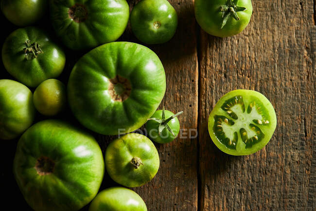 Vista dall'alto di fetta di bacca acerba di impianto di lycopersicum Solanum con pomodori sparsi — Foto stock