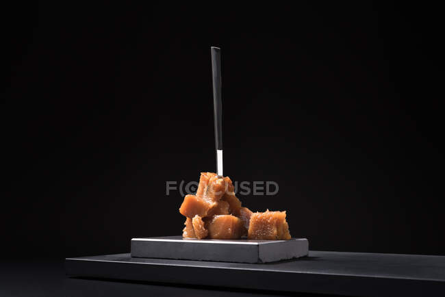 Gourmet pasta de membrillo jalea en placa de cerámica sobre fondo negro con tenedor - foto de stock