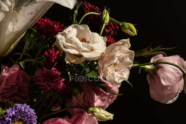 Buquê de flores frescas, incluindo lírios brancos eustoma e aster em vaso de vidro ao sol — Fotografia de Stock