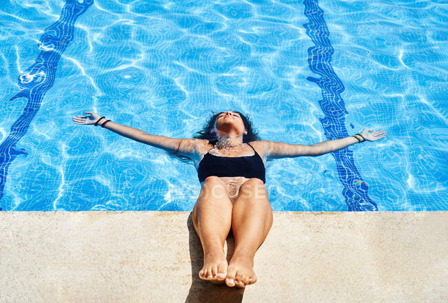 De cima de encantadora jovem em biquíni nadando na piscina com água clara no verão — Fotografia de Stock