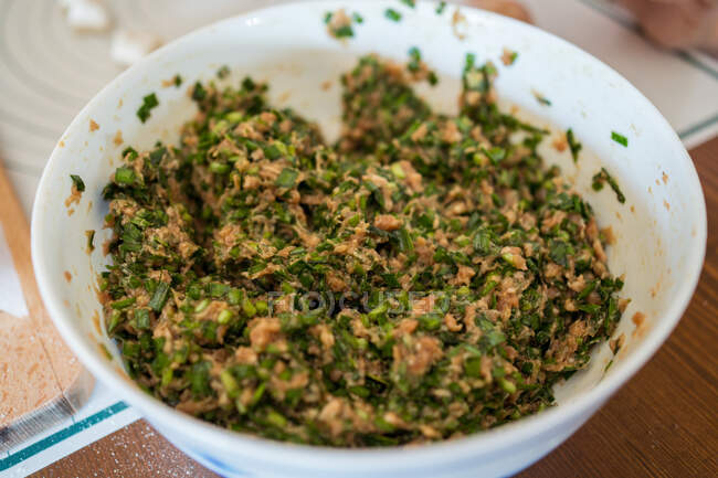 Dall'alto ciotola con carne macinata cruda ed erbe per gnocchi jiaozi — Foto stock