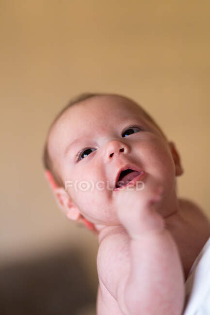 Side view of crop anonymous person embracing and caressing adorable baby in daytime — Stock Photo