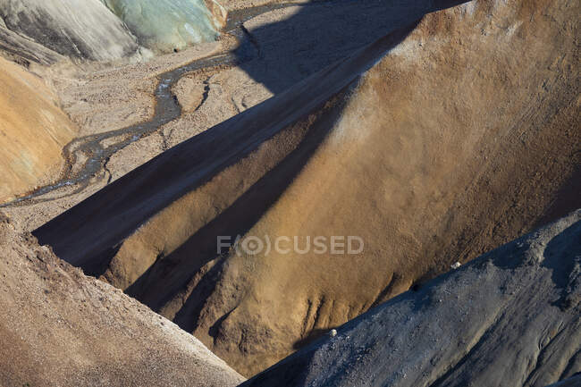 Steinige Formationen mit rauer, unebener Oberfläche in bergiger Gegend unter hellem Sonnenlicht in der Natur an einem sonnigen Tag in Island — Stockfoto
