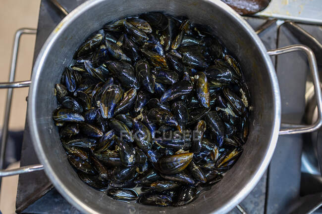 Top view of stainless saucepan with mussels cooking on stove for seafood dish in restaurant — Stock Photo