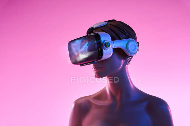 Frauenattrappe mit VR-Brille vor leuchtend rosa Hintergrund als Symbol futuristischer Technologie — Stockfoto