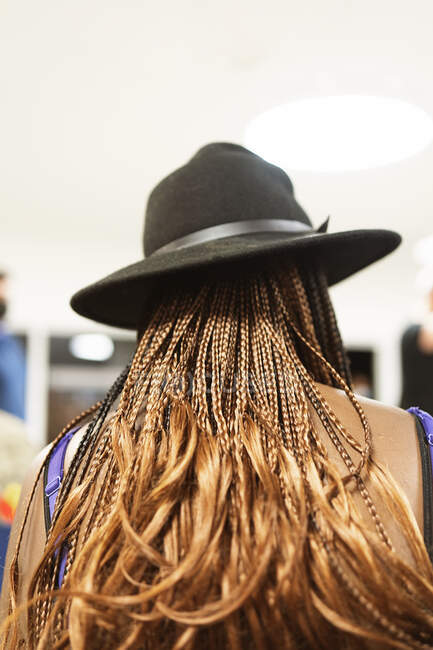 Vista posteriore di donna afroamericana irriconoscibile con lunghe trecce in elegante cappello in piedi sulla strada nella giornata di sole — Foto stock