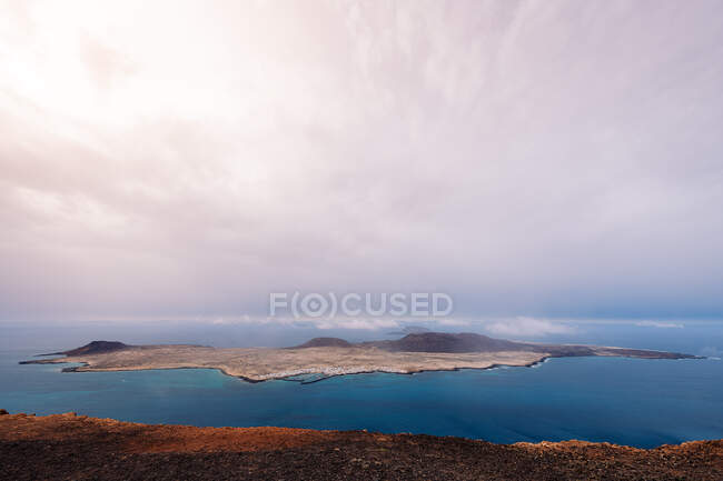 Picturesque view of Graciosa Island with volcanic mounts among Strait of Rio at sundown in Teguise Lanzarote Spain — Stock Photo