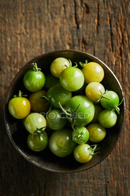 Dall'alto di pomodori ciliegia verdi interi in boccia raccolti in fattoria durante stagione di raccolto — Foto stock