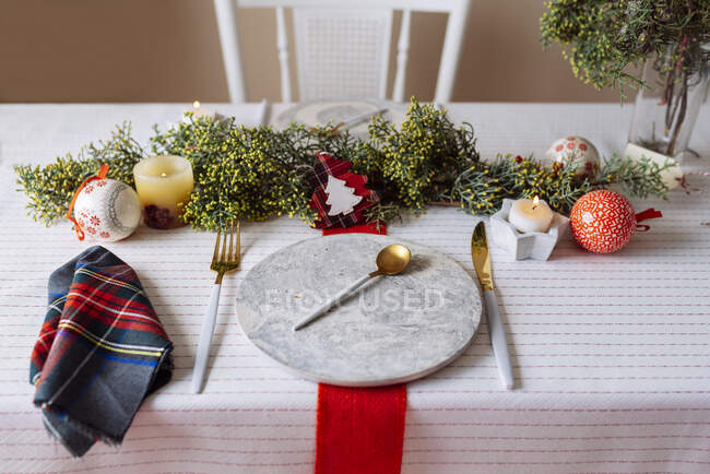 Сверху Рождественский стол с венком украшения, красный и белый, с золотыми столовыми приборами и свечами — стоковое фото