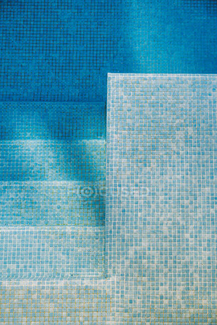 Vista superior do fundo de azulejos e degraus na piscina com água azul limpa — Fotografia de Stock