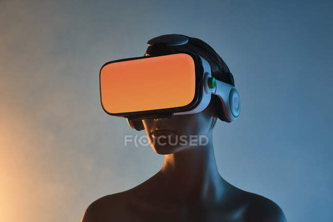 Maniquí femenino con gafas VR colocadas sobre fondo azul brillante como símbolo de la tecnología futurista - foto de stock