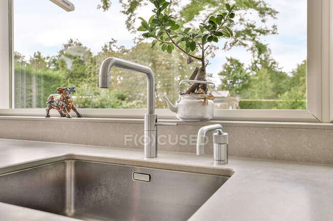 Progettazione creativa di cucina con lavandino contro finestra in casa — Foto stock