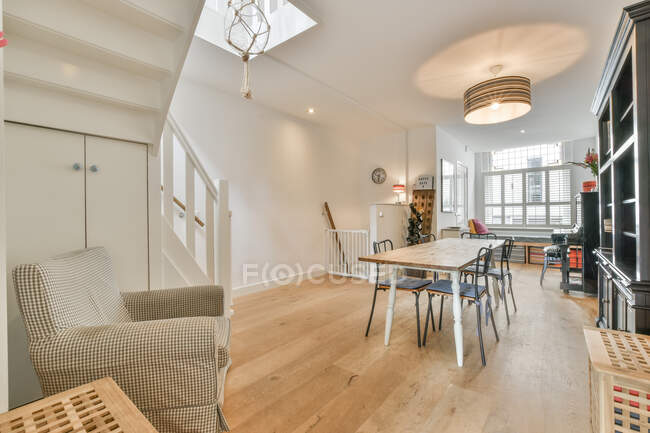 Interno di spazioso appartamento luminoso con design moderno e mobili in legno decorato con lampade e pianoforte durante il giorno — Foto stock