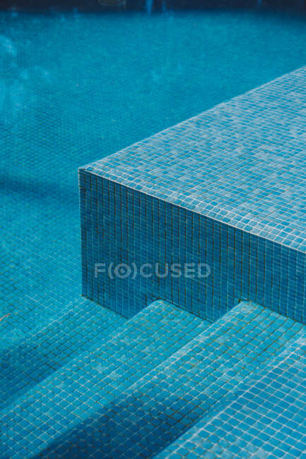 De cima do fundo de azulejos e passos na piscina com água azul limpa — Fotografia de Stock