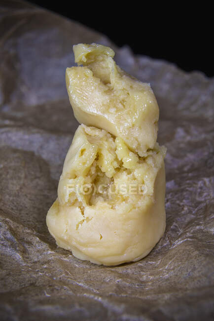 Closeup pedaços amarelos de resina de pólen de maconha colocados em pedaço de papel manteiga — Fotografia de Stock