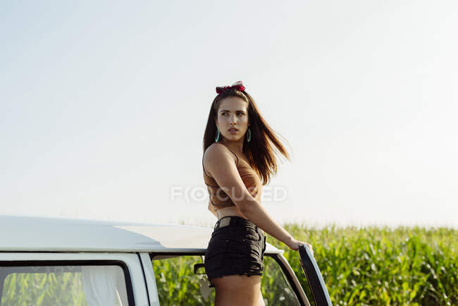 Bella e felice ragazza bruna in piedi su un furgone in una giornata di sole — Foto stock