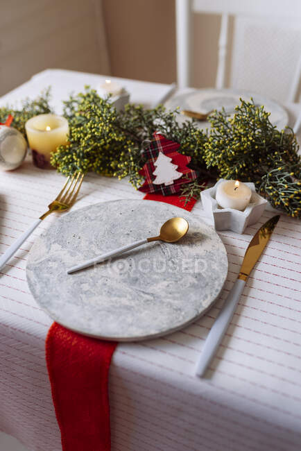 De haut de table de Noël avec une décoration de couronne, rouge et blanc, avec couverts dorés et bougies — Photo de stock