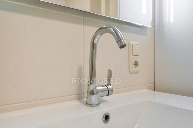 Waschbecken Wasserhahn in zeitgenössischem Badezimmerinterieur unter Spiegel im Haus — Stockfoto