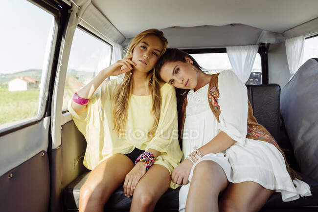 Девушки в поездке в сельской местности сидят в фургоне, пока смотрят в камеру — стоковое фото