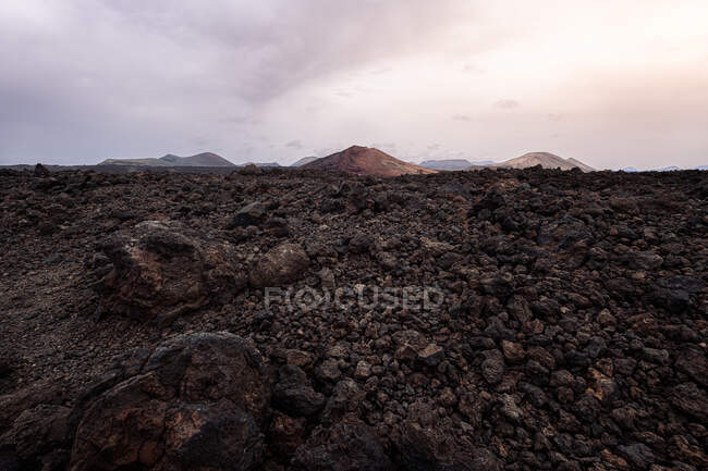 Unwegsamer Weg zwischen dunkler Lava und dem Vulkan Bermeja in Yaiza, Lanzarote, Kanarische Inseln in Spanien — Stockfoto