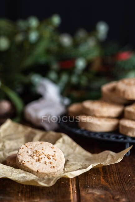 Pile of appetizing sweet shortbread cookies with hazelnuts served on plate on wooden table with festive wrapping paper and ribbons for Christmas celebration — Stock Photo