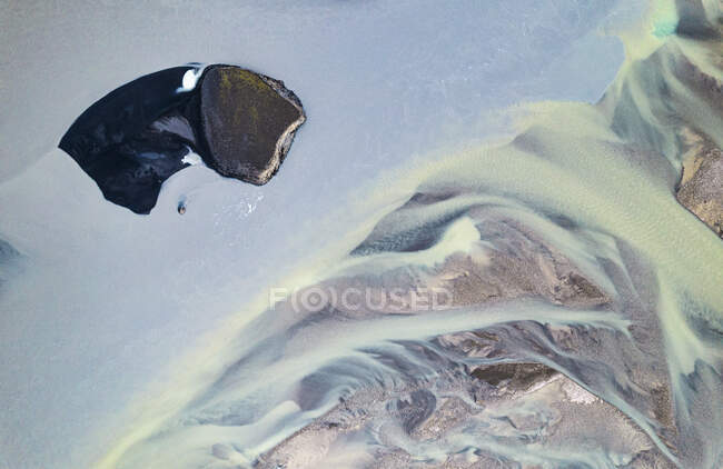 Dall'alto di formazioni sassose con superficie irregolare coperta di neve bianca situata nella natura dell'Islanda durante la fredda giornata invernale — Foto stock