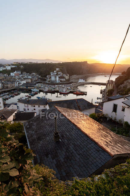 Dall'alto di case residenziali situate nella zona costiera sulla riva erbosa vicino all'acqua calma con varie barche nelle Asturie — Foto stock