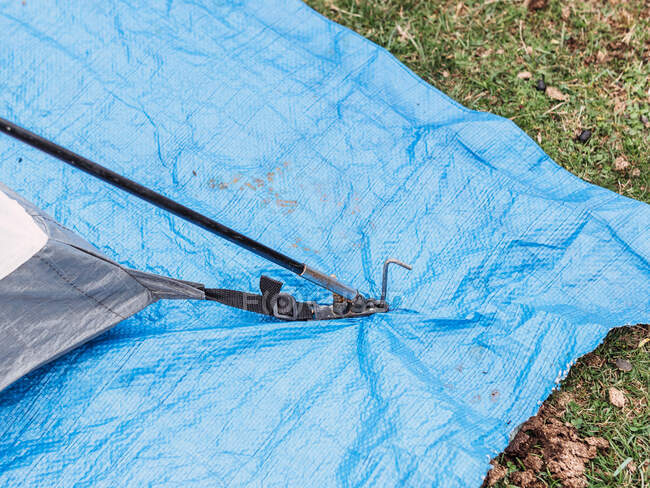 Dall'alto della tenda da campeggio posto su materiale di nylon blu su terreno erboso in natura — Foto stock