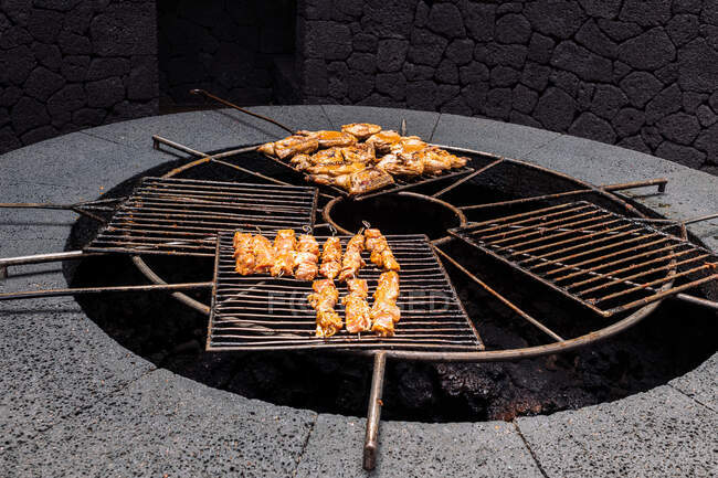 Deliziosi pezzi di pollo su rack sopra il calore del vulcano nel Parco Naturale di Timanfaya a Lanzarote Spagna — Foto stock
