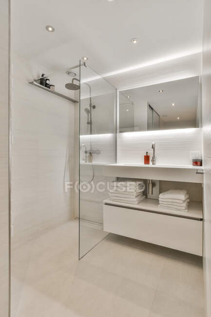 Modernes Badezimmer mit Waschbecken und Spiegel gegen Duschbad mit Glaswand im Leuchtturm — Stockfoto
