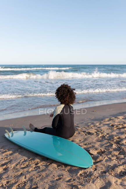 Ganzkörper anonymer Barfuß-Surferin im Neoprenanzug am Sandstrand in der Nähe des winkenden Meeres — Stockfoto