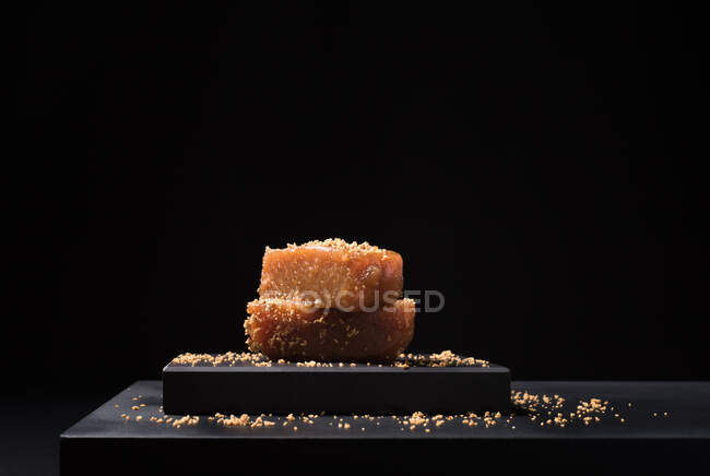 Gourmet pâte de gelée de coing dans une assiette en céramique saupoudrée de graines de sésame sur fond noir — Photo de stock