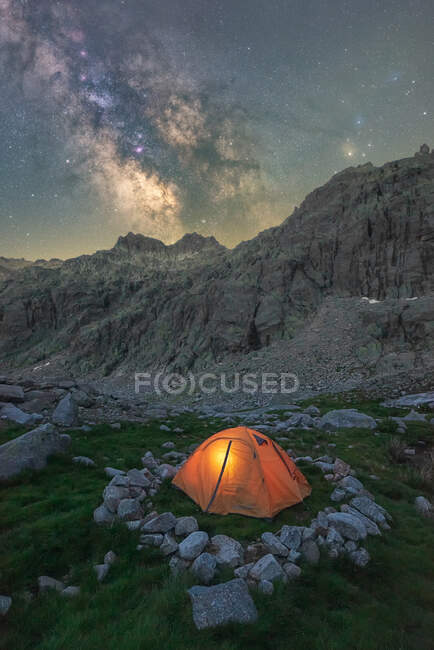 Picturesque view of tent on grass with stones against rugged mount under starry milky way sky in twilight located in Circo de Gredos cirque in Spain — Stock Photo