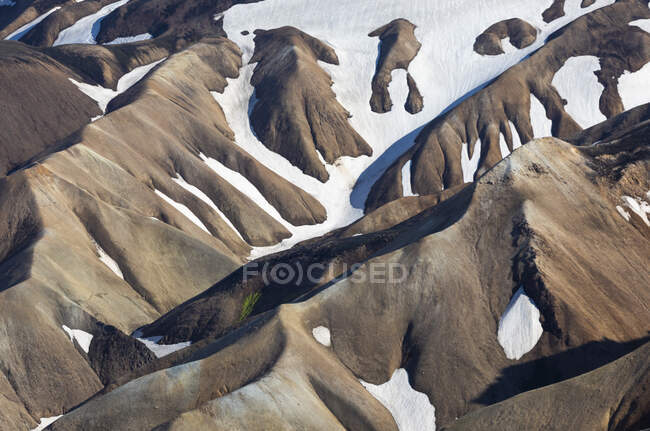 Formazioni rocciose accidentate ricoperte di neve bianca situate in terreni montuosi nelle fredde giornate invernali nella natura islandese — Foto stock