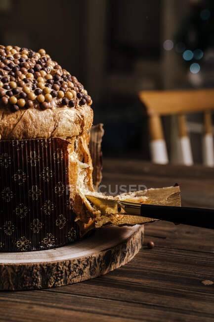 Crop unrecognizable female with knife chopping traditional Italian panettone prepared for dinner for celebrating Christmas — Stock Photo