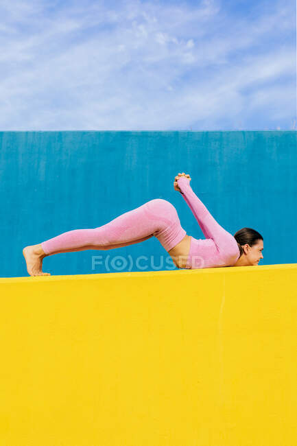 Side view of full body barefoot woman stretching in variation of Reversed Locust pose with raised arms and straight legs — Stock Photo