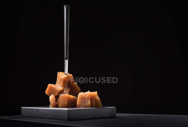 Gourmet pasta de membrillo jalea en placa de cerámica sobre fondo negro con tenedor - foto de stock