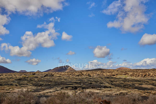 Wide angle view of rocky dry hills located in highlands against cloudy sky in summer in Fuerteventura, Spain — Stock Photo
