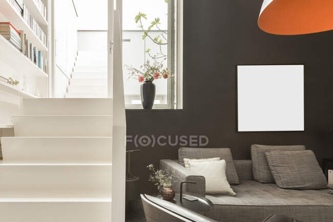 Design de interiores de sala de estar com sofá confortável e poltrona de couro em apartamento moderno com paredes brancas e pretas — Fotografia de Stock