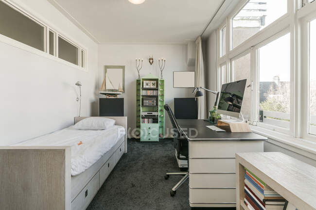 Aménagement intérieur de la chambre contemporaine avec lit simple et lieu de travail moderne avec ordinateur — Photo de stock