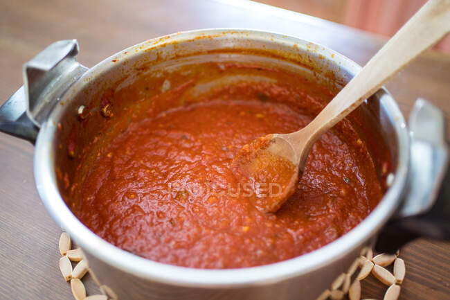 Cocinar salsa marinara de tomates en la estufa en la cocina - foto de stock