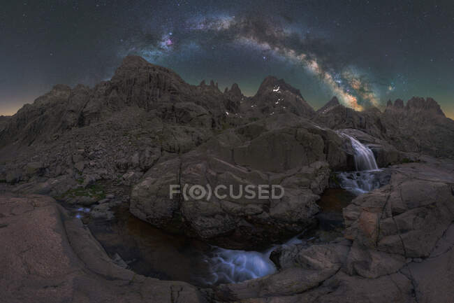 Vista espetacular de altas montagens ásperas com cascata e rio sob céu estrelado com galáxia à noite — Fotografia de Stock