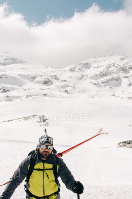 Athlete on skis on Pico Aunamendi in snowy Pyrenees Mountains under cloudy sky in Navarre Spain — Stock Photo
