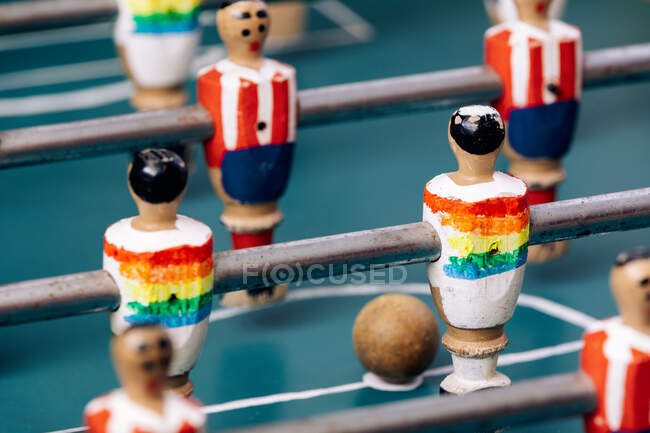 Alto ángulo de detalle de futbolín retro con figuras en miniatura de madera de jugadores en barras de metal - foto de stock