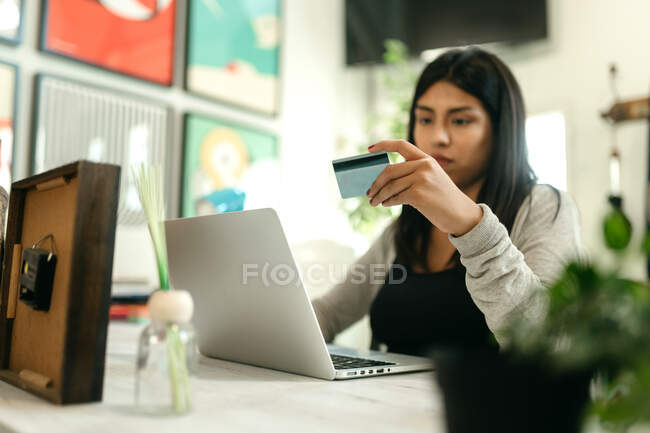 Acquisto femminile con carta di plastica per l'ordine durante lo shopping online tramite laptop — Foto stock