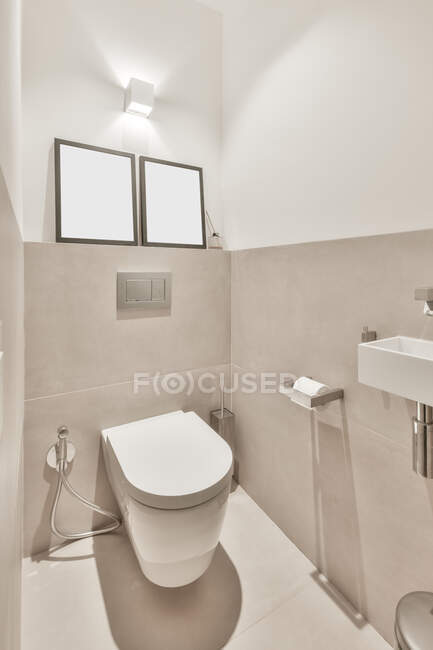 Interior do banheiro moderno com banheiro branco colocado perto da pia — Fotografia de Stock