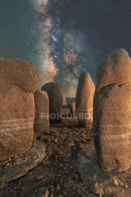 Pintoresca vista de Stonehenge español en terreno accidentado bajo el cielo del atardecer con galaxia en Cáceres España - foto de stock