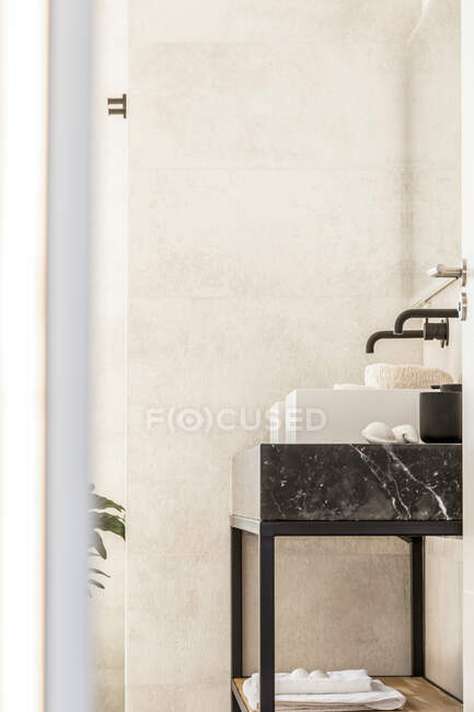 Современные белые двойные раковины в ванной комнате с черными кранами, выполненными в минимальном стиле в квартире — стоковое фото