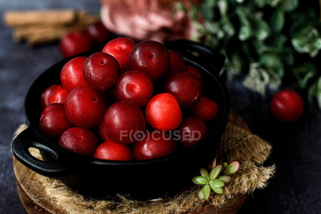 Tigela com ameixas doces frescas servidas na mesa preta — Fotografia de Stock